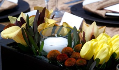 centerpiece with yellow roses and a candle