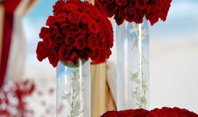 red bouquets of flowers in tall glassware